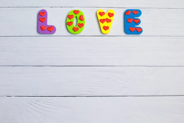 Palabra Amor sobre fondo de madera primer plano. Concepto para el Día de San Valentín fondo . — Foto de Stock