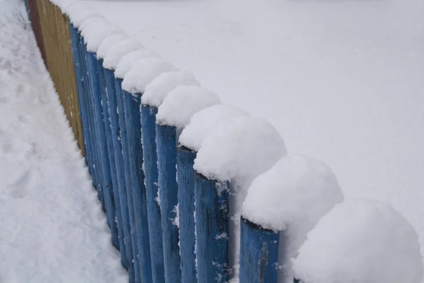 Sneeuw op een houten hek als achtergrondafbeelding. Rustieke houten hek bedekt met sneeuw — Stockfoto