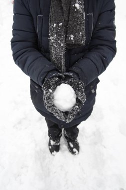 Kış parkta genç çocuk bir kartopunun içinde tutan eller