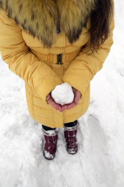 Bir kartopunun içinde tutan genç kız kış parkta eller