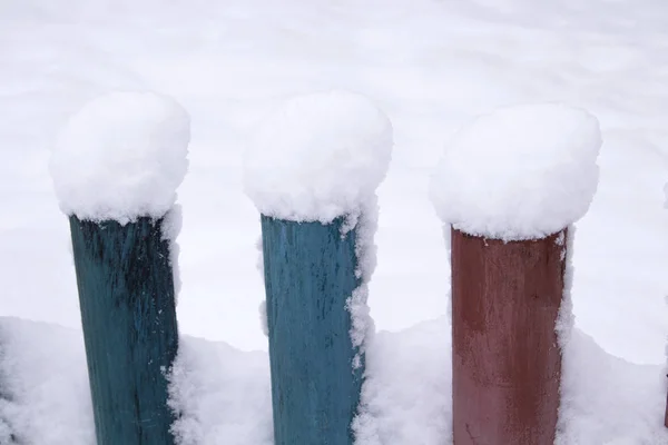 snow on a wooden fence as a background image. Rustic wooden fence covered with snow