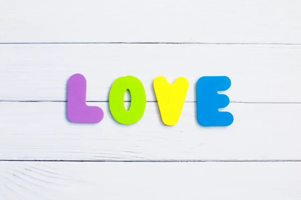 Palabra Amor sobre fondo de madera primer plano. Concepto para el Día de San Valentín fondo . — Foto de Stock