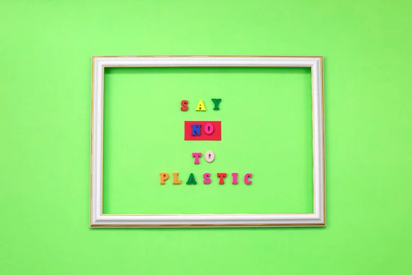 Say NO to plastic - on wooden letters on green background. Environmental, pollution concept