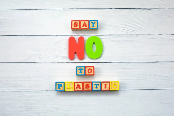 Say NO to plastic - on wooden cubes on wood background. Environmental, pollution concept