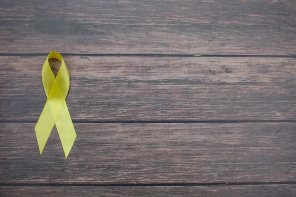 Желтый цвет ленты символизирует рак костей саркомы, рак мочевого пузыря, болезнь печени, осведомленность о Spina Bifida — стоковое фото