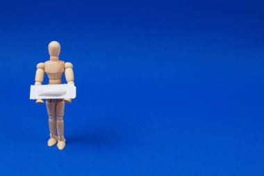 Tıbbi fitil, rektal veya vajinal. Tahtadan adamın tıbbi fitil mavi arka plan üzerinde tutar..