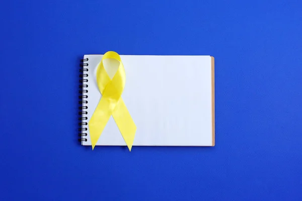 Geel lint - blaas, lever en bot kanker bewustzijn symbool. Steun onze troepen concept. — Stockfoto