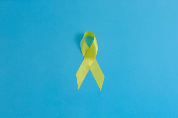 Geel lint - blaas, lever en bot kanker bewustzijn symbool. Steun onze troepen concept. — Stockfoto