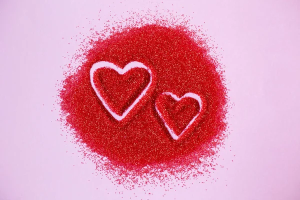Δυο καρδιές που συντάσσεται με το χέρι στην κόκκινη ζάχαρη σε ροζ φόντο. Ευχές για του Αγίου Βαλεντίνου. Κάρτα γάμου — Φωτογραφία Αρχείου