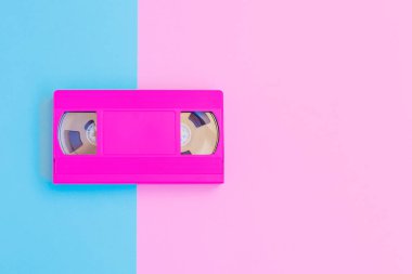 VHS kaset yumuşak pembe ve mavi Kağıt arka plan üzerinde. En az kavramı. Yaratıcı kavramı. Sinema kavramı. Pop Art. Parlak tatlı moda stil.