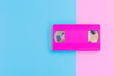 VHS kaset yumuşak pembe ve mavi Kağıt arka plan üzerinde. En az kavramı. Yaratıcı kavramı. Sinema kavramı. Pop Art. Parlak tatlı moda stil.