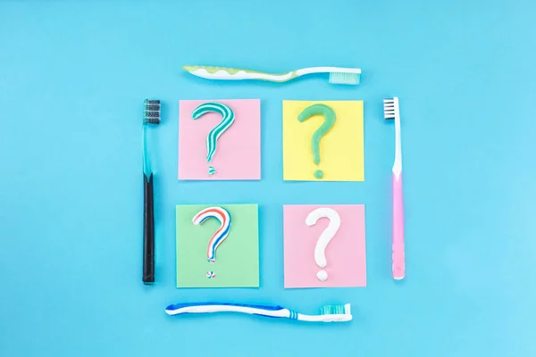 Symbol of question mark from toothpaste and toothbrush on blue background, — Stock Photo, Image