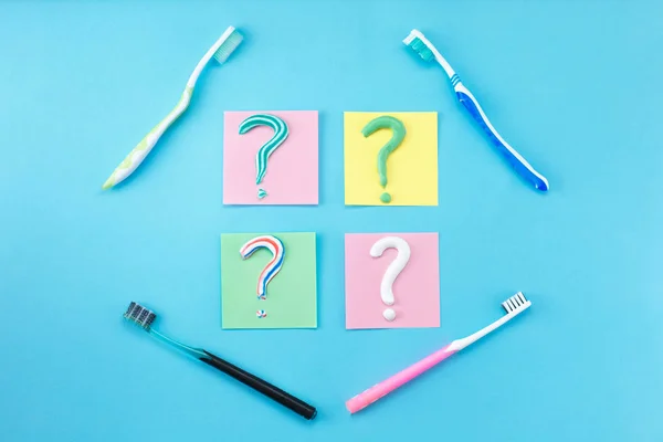 Symbol of question mark from toothpaste and toothbrush on blue background, — Stock Photo, Image