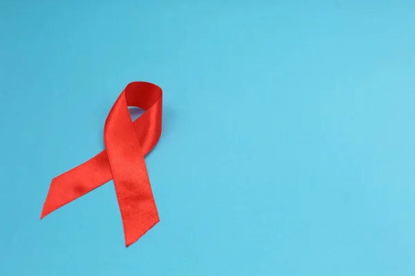 Consapevolezza del nastro rosso su sfondo blu sull'HIV, cancro al giorno . — Foto Stock