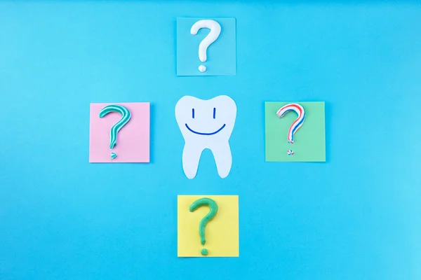 Symbol of question mark from toothpaste on blue background,