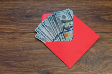 Bize doları banknot ahşap masa, bonus, ödül, faydaları kavramı kırmızı zarf içinde.