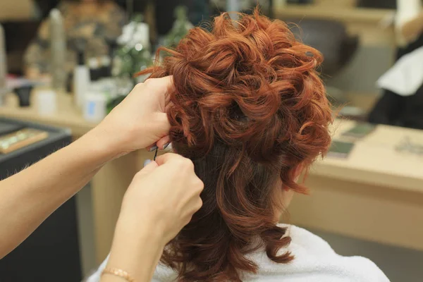 Peluquería hace hermoso peinado en el salón — Foto de Stock
