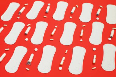 Birçok tampon ve hapları kırmızı zemin üzerine beyaz yığını pedleri.