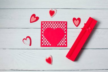 Kırmızı kurdele ve ahşap arka plan üzerinde kalpleri ile Hediyelik kullanır. Bayan Sevgililer günü. Metin, kopya alanı için yer.