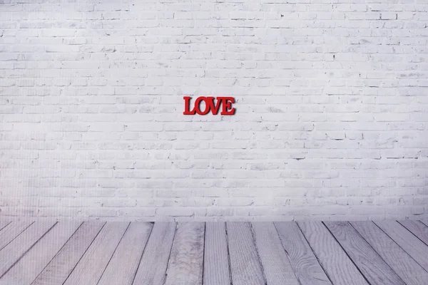 Λέξη αγάπη από ξύλινα γράμματα στον τοίχο του λευκού τούβλο. — Φωτογραφία Αρχείου