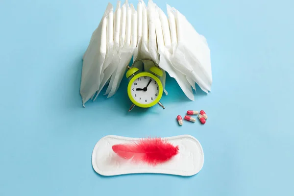 Menstruáció ciklus fogalma. Menstruáció naptár betétekkel, fogamzásgátló tabletták, virágok és ébresztőóra. — Stock Fotó