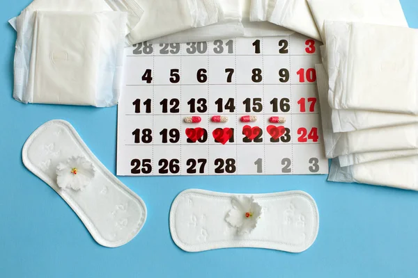 Konsep siklus menstruasi. Kalender menstruasi dengan pembalut, pil kontrasepsi dan bunga . — Stok Foto