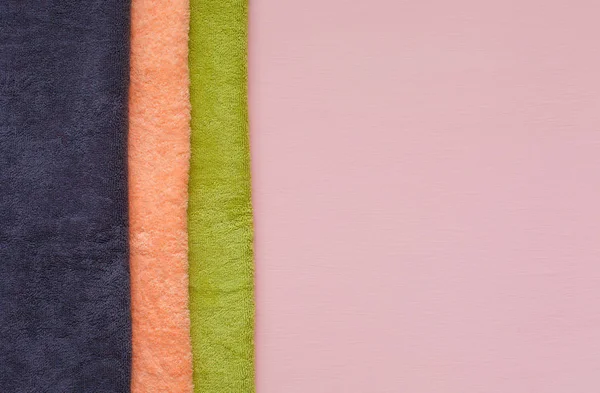 Pila di asciugamani in spugna su sfondo rosa. Giorno di lavanderia . — Foto Stock