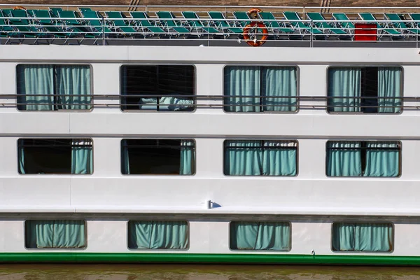 Uma vista lateral de um grande navio de cruzeiro mostrando o convés principal e espreguiçadeiras — Fotografia de Stock