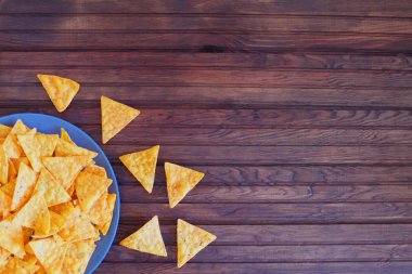 Cips mısır cipsi rustik ahşap arka plan üzerinde. Üstten yatay görünüm. Tasarım kopyalama alanı malzemeleri