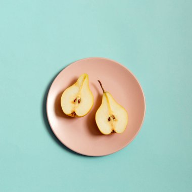 Olgun armut mavi renkli bir tabağa dilimlenmiş.