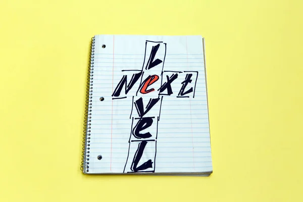 Texto de escritura de palabras Next Level en un cuaderno sobre fondo amarillo. Concepto de negocio para tener más de una planta — Foto de Stock