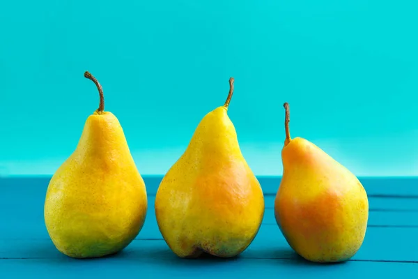 Pear decoration stock images. Yellow pear on blue background. Pear home decor. Yellow decorative pear