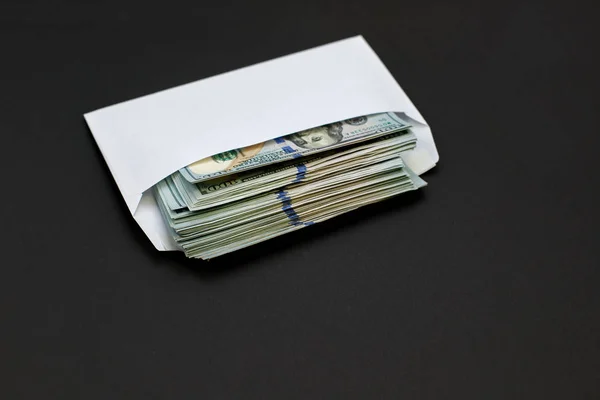 Dollar money in the envelope on black background bonus, reward, benefits concept.