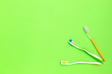Yeşil zemin üzerine farklı diş fırçaları kümesini. Kişisel bakım kavramı. Düz yatıyordu.