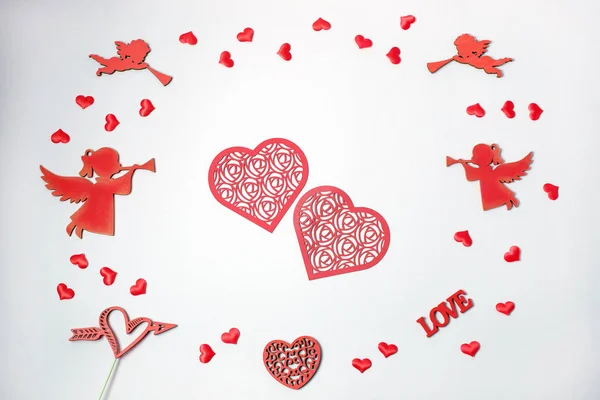 Valentinstag. Rahmen aus Herzkonfetti, Engeln und Postkarte auf weißem Hintergrund. Valentinstag Hintergrund. flache Lage, Draufsicht, — Stockfoto