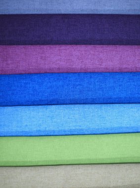 Tekstil örnekleri. Tekstil örnekleri perdeler için. Mavi mor, yeşil tonu perde örnekleri asılı.