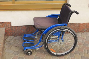 Sokakta bir salonu yanındaki boş tekerlekli sandalye