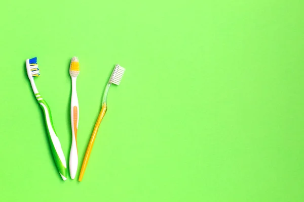 Set of different toothbrushes on green background. Personal care concept. Flat lay. — Stock Photo, Image