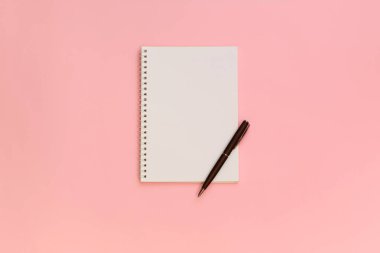 Pastel pembe üzerinde üstten görünüm kalemi kağıdına boş Not. Geri okul ve eğitim kavramı