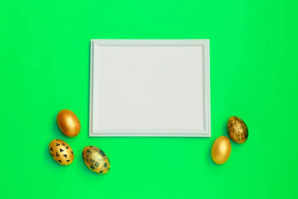 Marco con huevos de Pascua moteados de oro con espacio de copia para texto sobre fondo verde. Concepto de Semana Santa Mínima Feliz. flatlay . — Foto de Stock