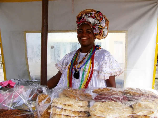 El Salvador, Brasil. Noviembre-11 de 2016. Mujer brasileña de ascendencia africana vestida con ropa tradicional vende galletas — Foto de Stock