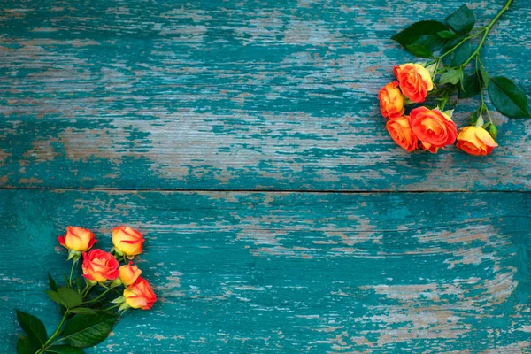 Tło bukiet pięknych świeżych żywych róż pomarańczowych na świętowanie Walentynki, urodziny lub dzień matki na zielonym drewnianym tle — Zdjęcie stockowe