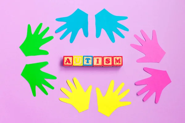 Концепція аутизму з відбитками рук дитини на фіолетовому тлі. Розлад аутистичного спектру. Вид зверху . — стокове фото