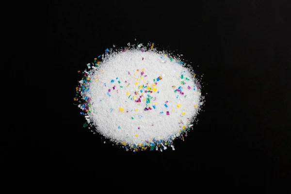 Microplastic particles in salt on black background. Water pollution. Threat to human health and environment Dangerous additives Toxic substances. — Stock Photo, Image