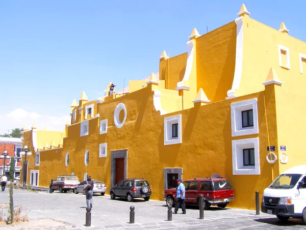 Merida, Mexico 11 maart 2016: straat scène met kleurrijke traditionele oude huizen en oude auto's op straat in Merida op warme zonnige dag. — Stockfoto
