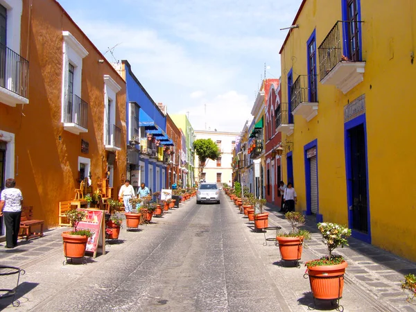 Меріда, Мексика 11 березня 2016: вулична сцена з барвистими традиційними старими будинками і старими автомобілями на вулиці в Меріда в спекотний сонячний день. — стокове фото