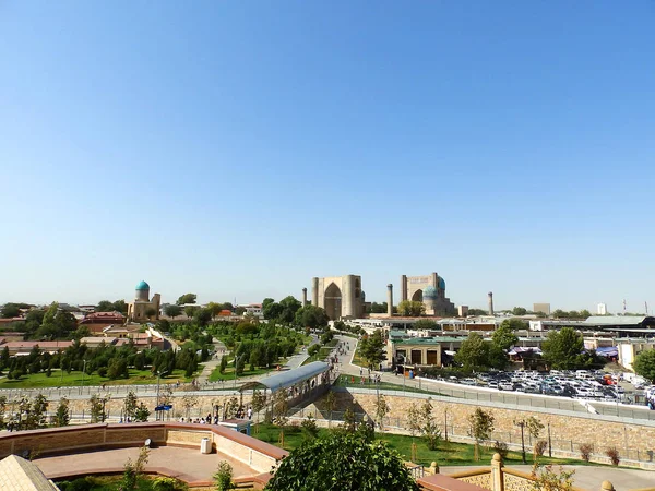 Samarcanda, Uzbekistan - 15 agosto 2018: Veduta della bellissima città vecchia - antica moschea Bibi-Khanym e parco verde sullo sfondo del cielo blu a Samarcanda e strada pedonale centrale — Foto Stock