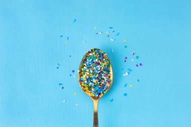 Microplastic in a spoon on blue background. microplastic in water and food. Microplastic problem. Dangerous additives. Toxic substances. clipart