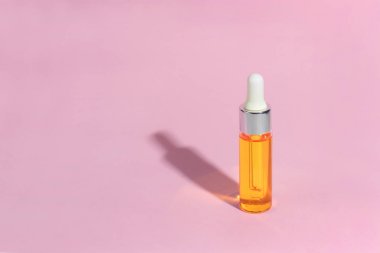 Damlalık cam Şişe Mock-Up. Pembe arka plan, afiş veya şablon serum cilt bakım kozmetik. Güzellik ürün konsepti.