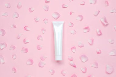 İlaç, kozmetik, krem, jöle, cilt bakımı için çiçek yapraklı beyaz parlak plastik tüp, pastel arka planda diş macunu..